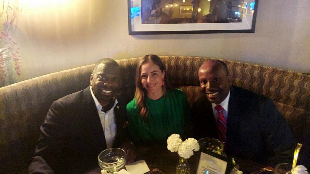 Three people sitting in a restaurant booth.