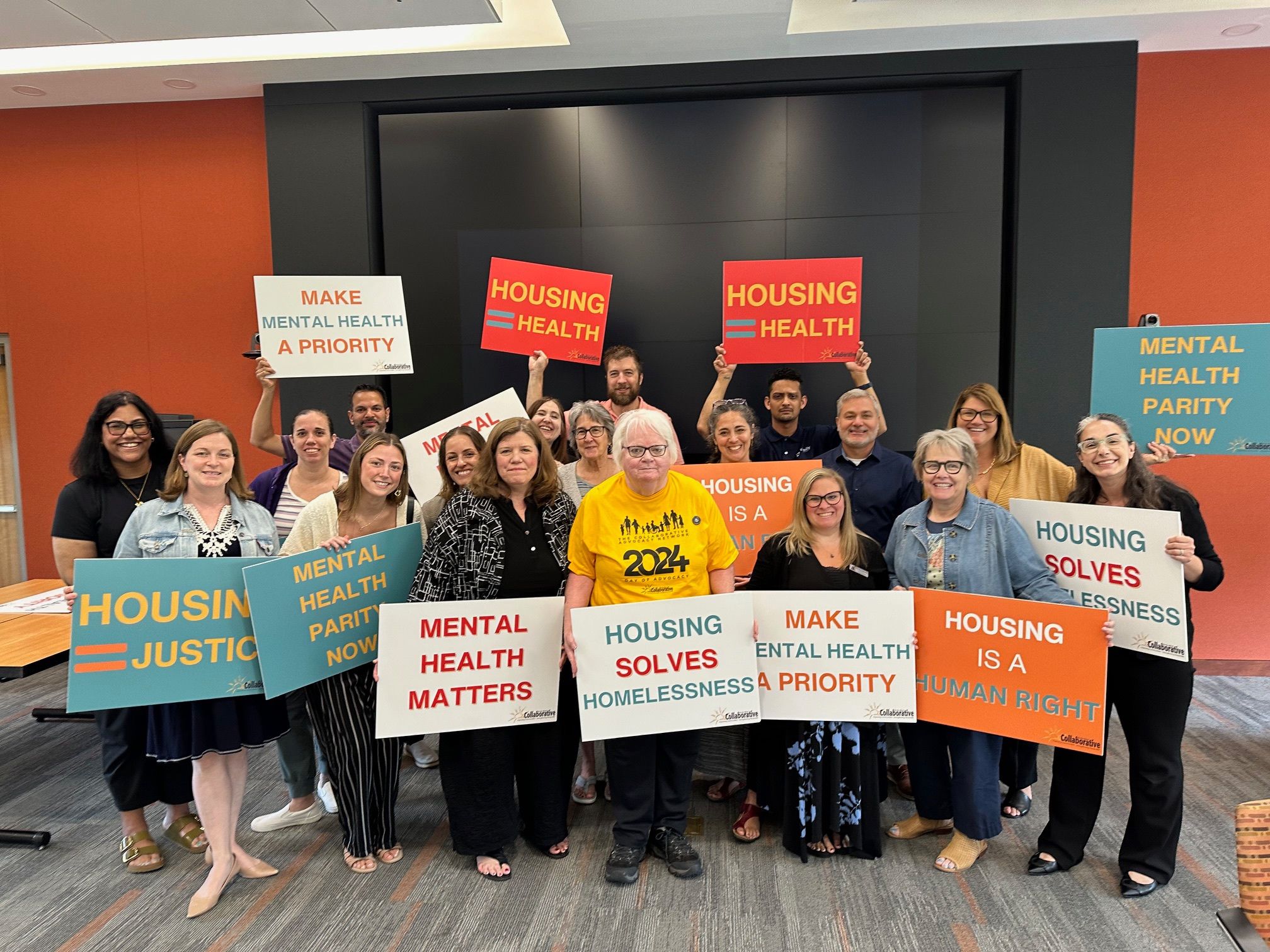 A group of people holding various advocacy signs.