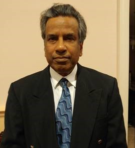Headshot of an Indian man in a dark suit.