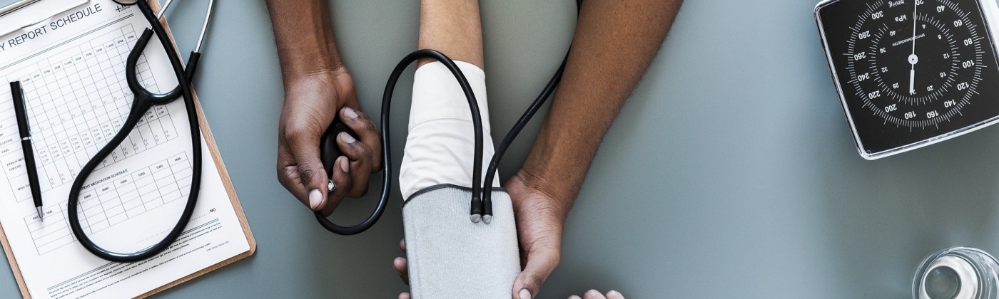 A nurse's hands taking a patient's blood pressure
