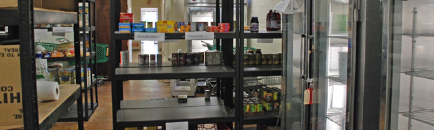 Shelves and glass-fronted refrigerators in a food pantry.