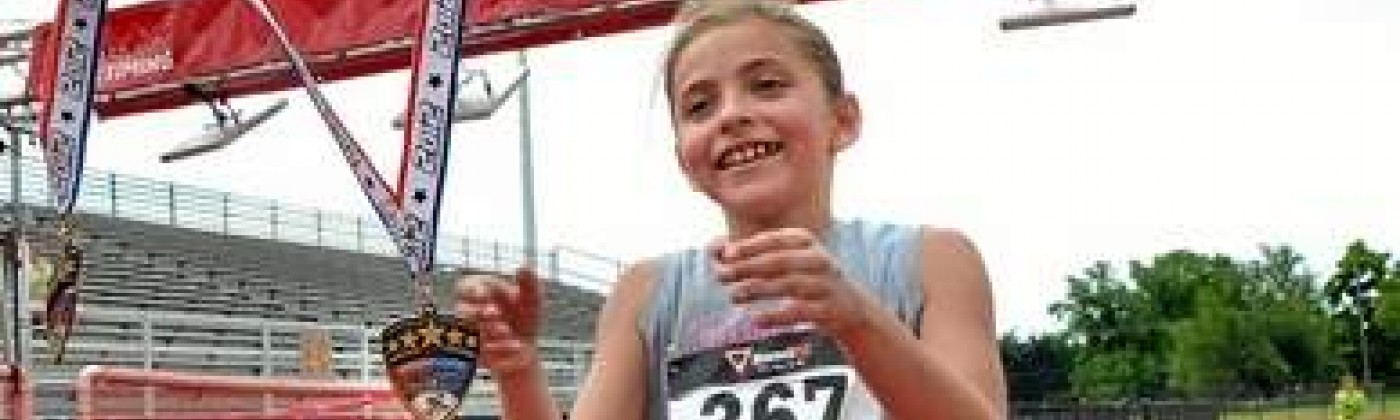 A girl accepts a medal for finishing a foot race.
