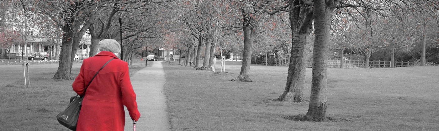 Elderly woman walking through the park