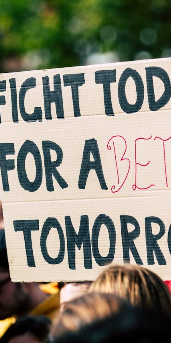 Person holding a sign that says "Fight today for a better tomorrow."