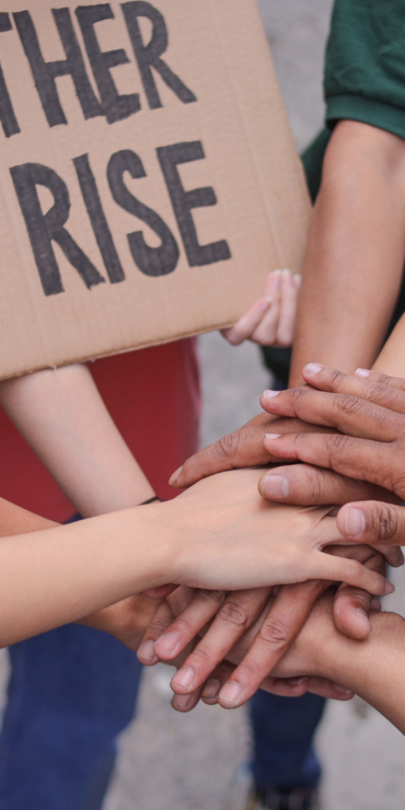 An image of multiple hands stacked on top of each other to express solidarity.