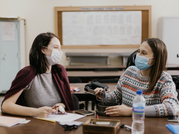 two young women wearing masks