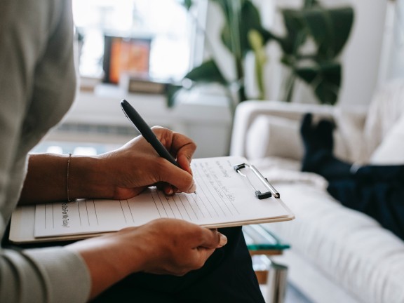 woman writing on clipboard