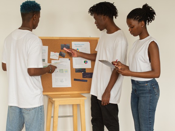group of young people reviewing data on bulletin board
