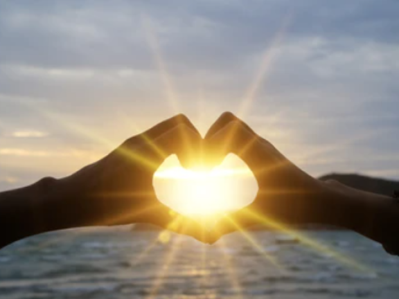 sunrise with hands in the shape of a heart