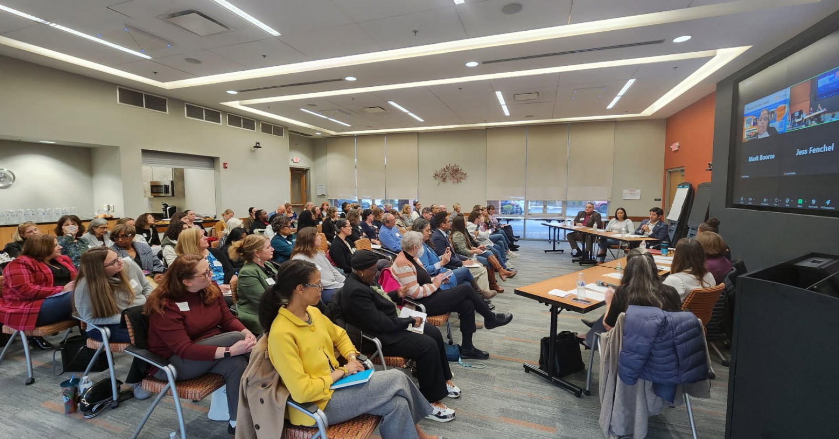 A group of people sitting in a conference room at a community event.