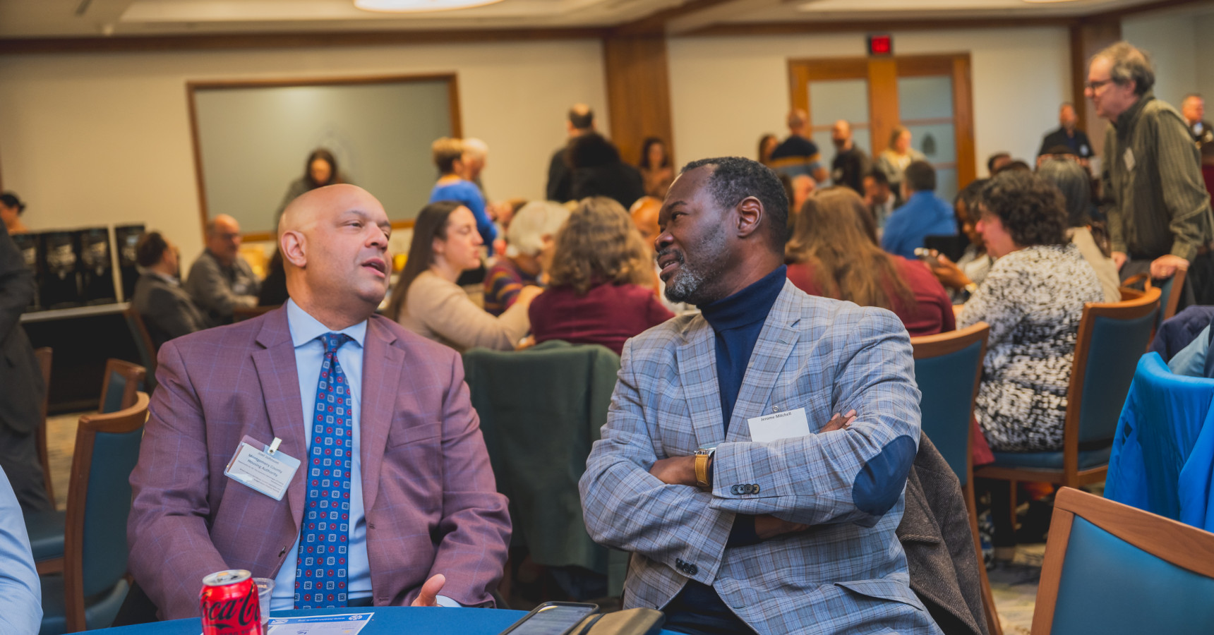 two men sitting at a table talking