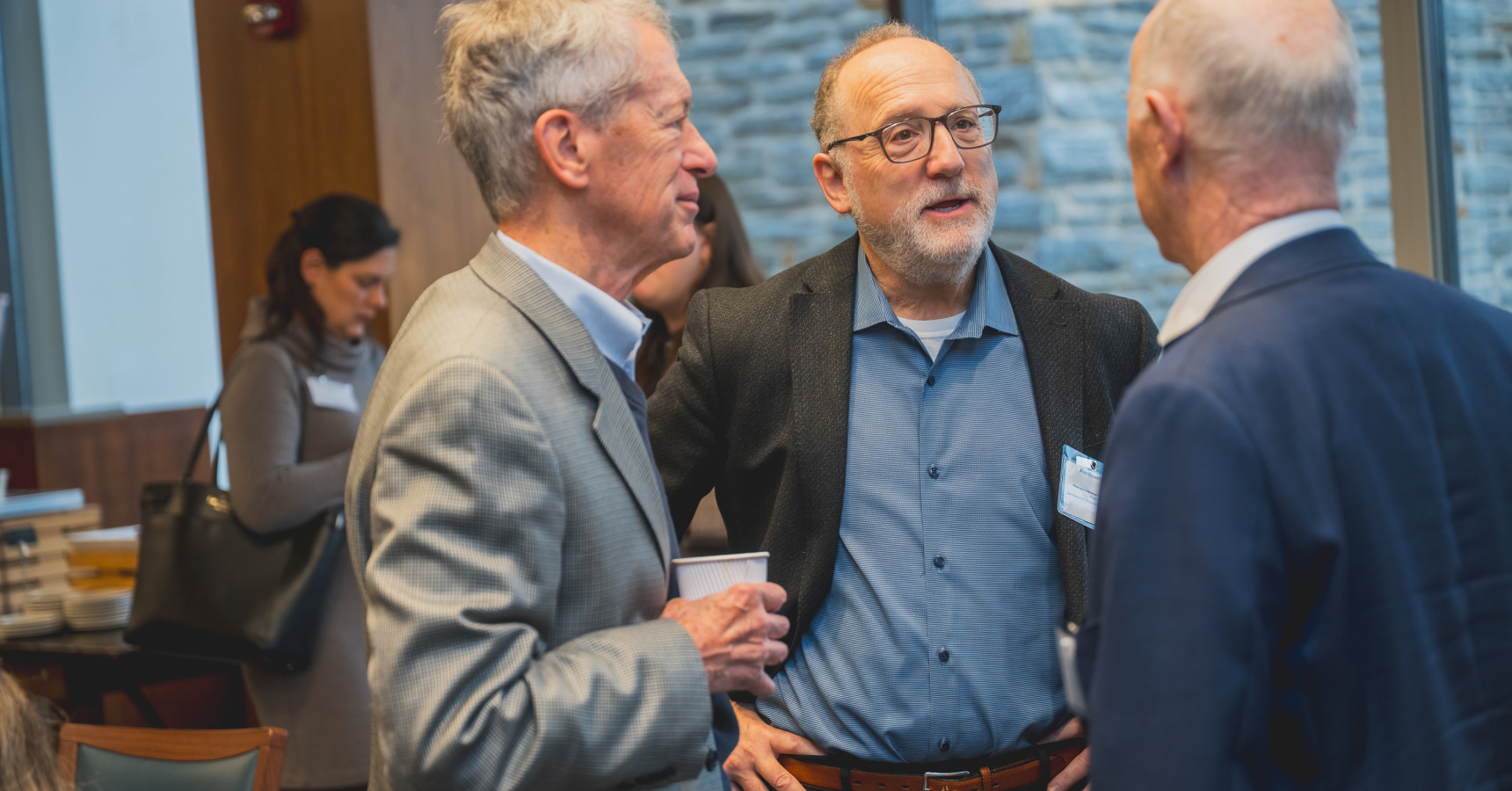 Three men talking to each other.