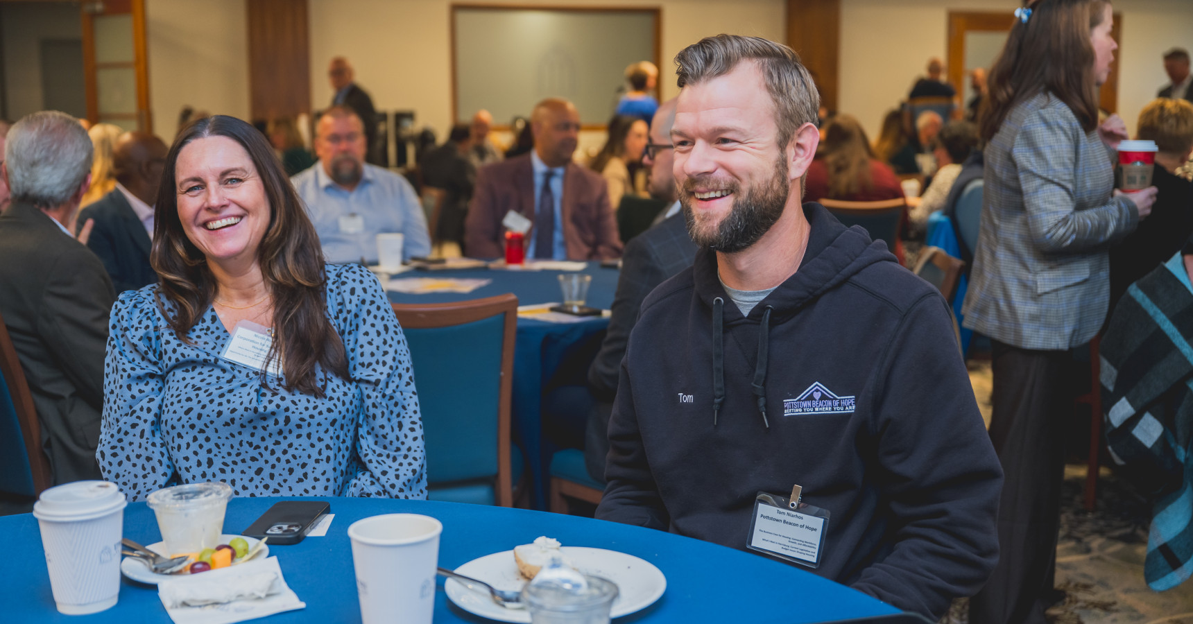 A man and a woman sitting at a table smiling.
