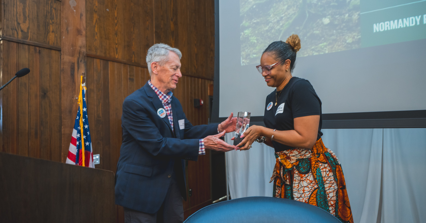 woman handing man an award