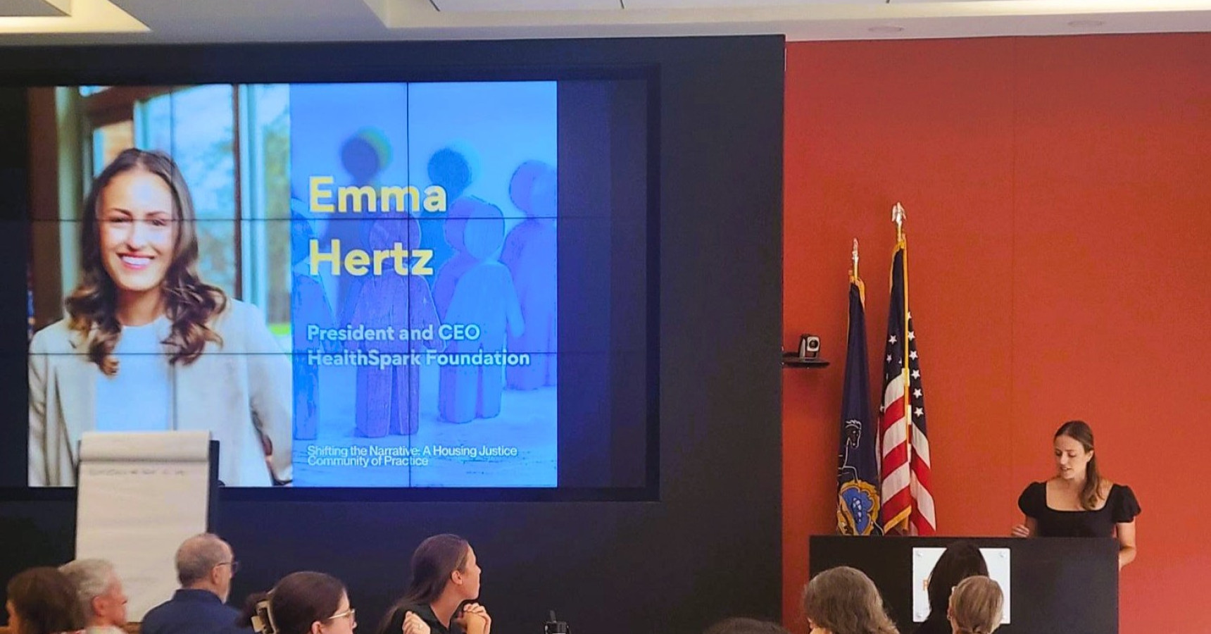 A woman speaks to attendees at a conference.