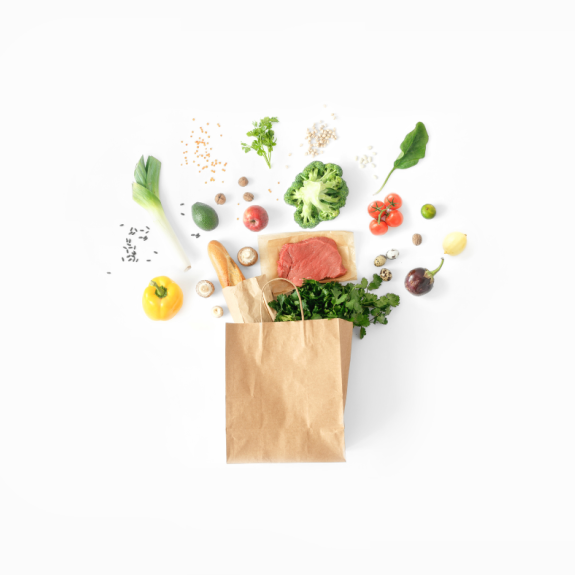 An image of vegetables, bread, and other produce coming out of a paper bag.