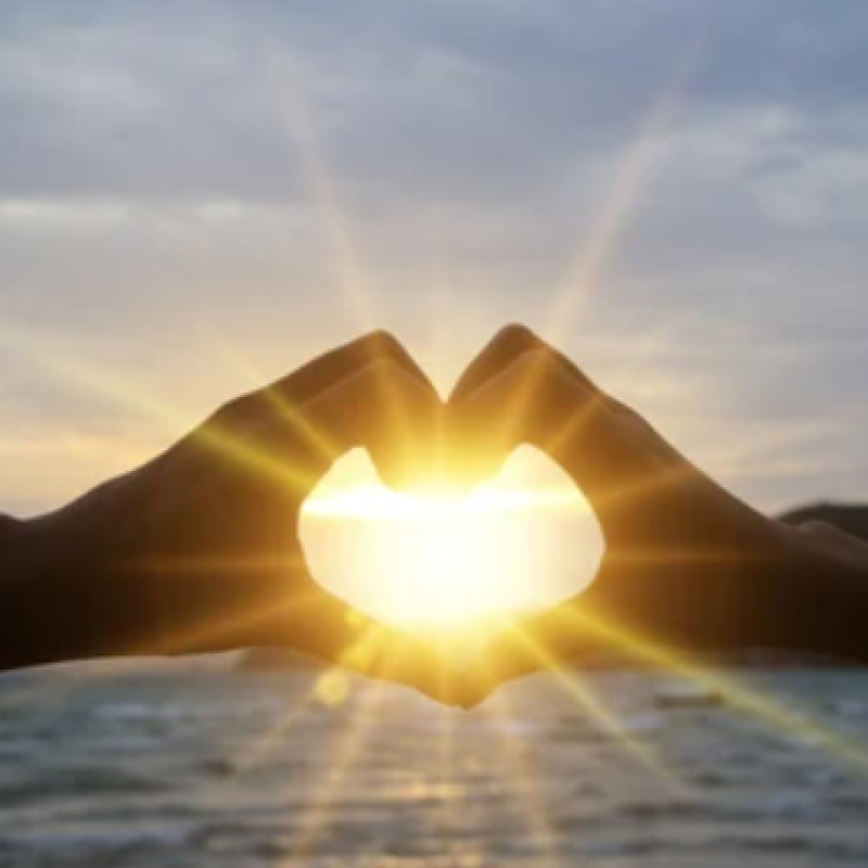 sunrise with hands in the shape of a heart