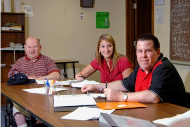 Three people sitting at a table.