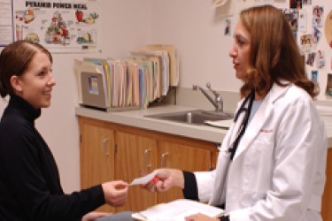 A doctor handing a patient a prescription.