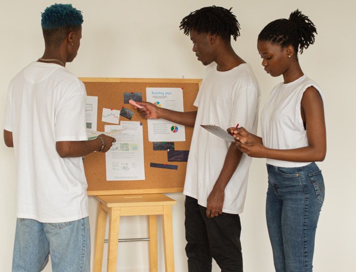 group of young people reviewing data on bulletin board