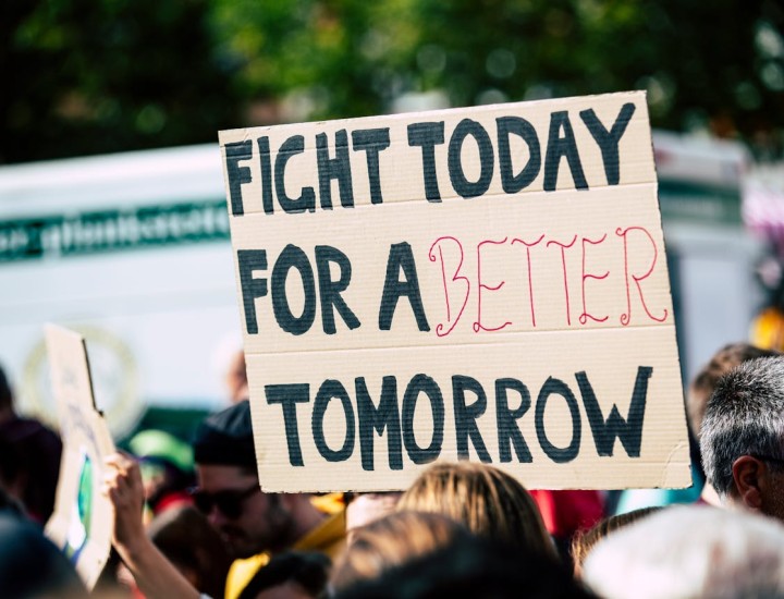 Person holding a sign that says "Fight today for a better tomorrow."