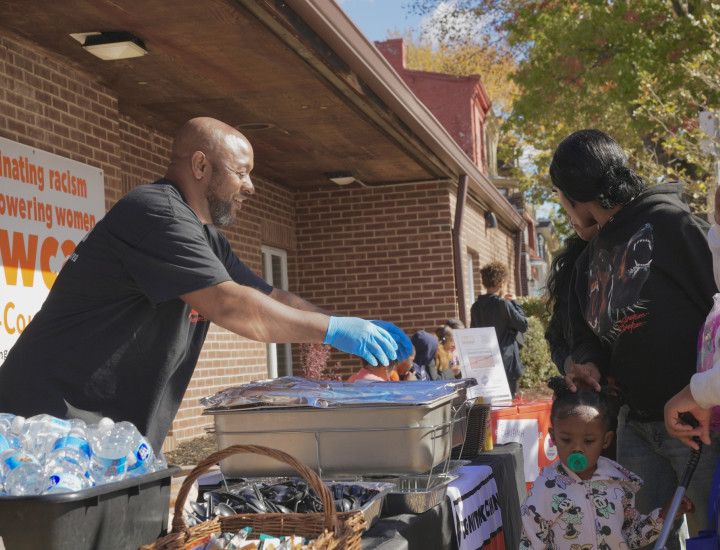 A man hands out catered food at a community event.